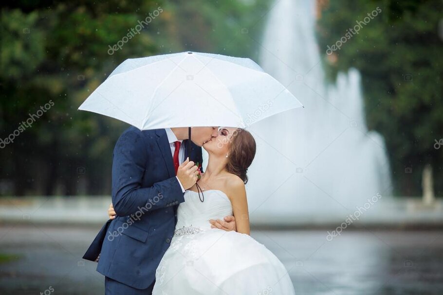 Hochzeitspaar unter transparentem Regenschirm bei Nieselregen