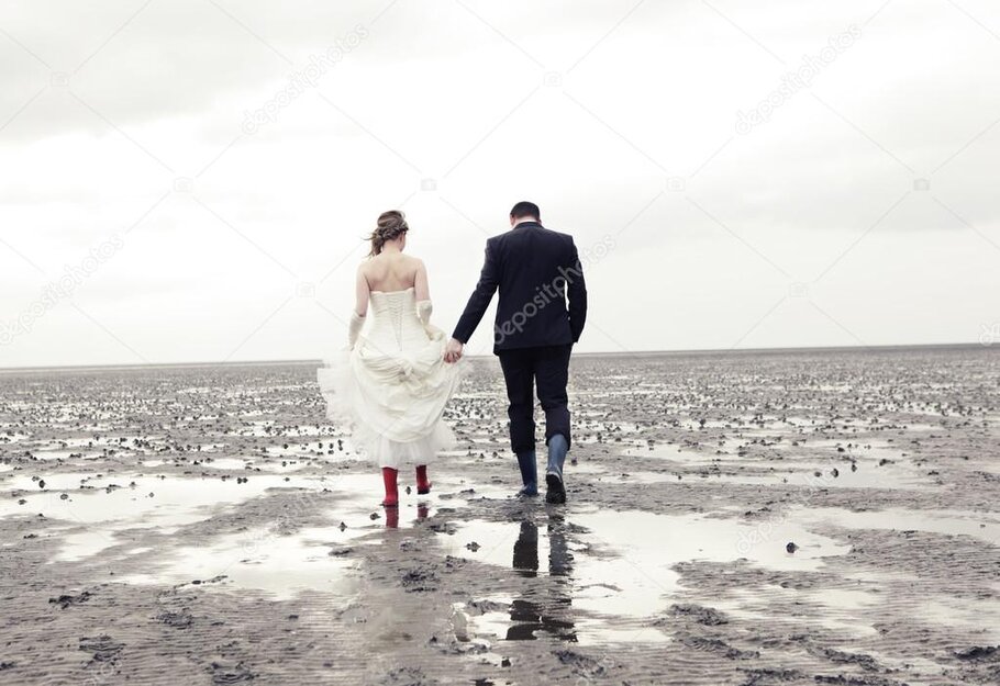 Paarshooting am Strand mit Leuchtturm im Hintergrund